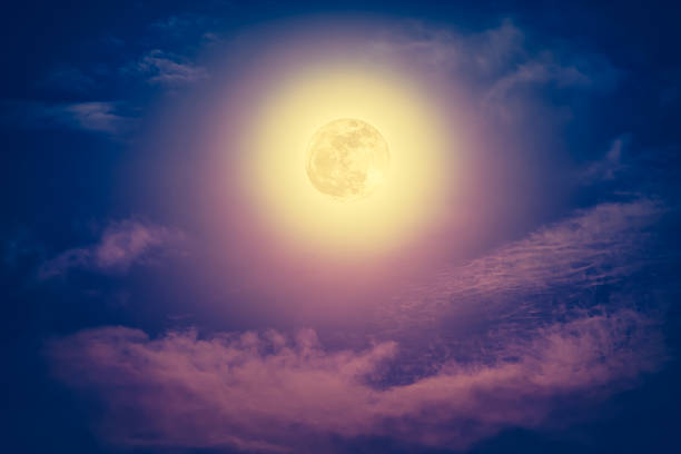 istock Nighttime sky with clouds and bright full moon with shiny. 635940874