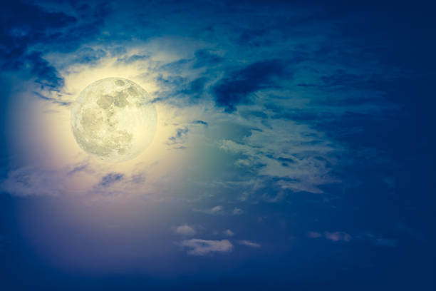 istock Nighttime sky with clouds and bright full moon with shiny. 635940918