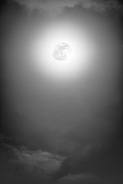 istock Nighttime sky with clouds and bright full moon with shiny. 635941122