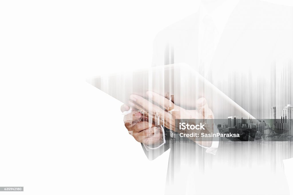 Double exposure businessman working on digital tablet with modern buildings Double exposure businessman working on digital tablet with modern buildings in the city, isolated on white background Multiple Exposure Stock Photo