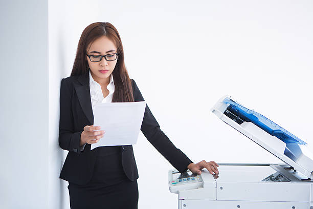 istock Asian Business Woman Reading Document at Copier 635949434