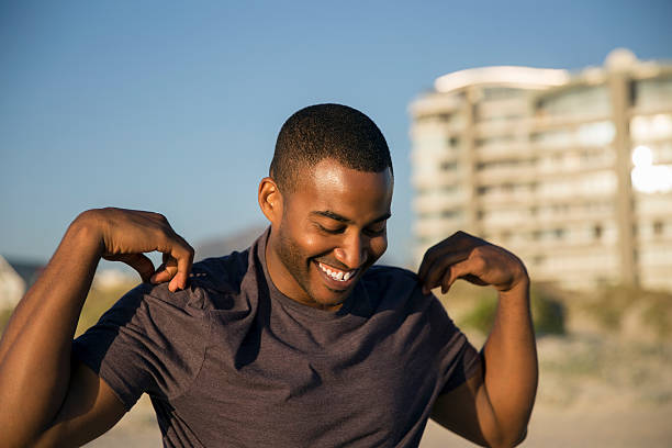 istock Happy male athlete warming up at beach 635949530