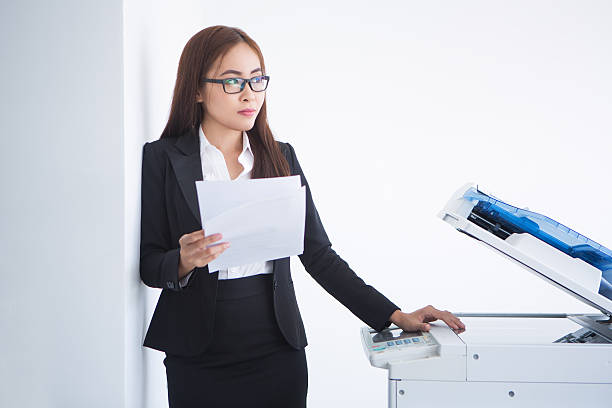 istock Pensive Business Woman at Copier with Document 635949676