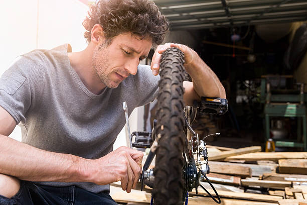 Male repairman fixing bicycle tire at workshop