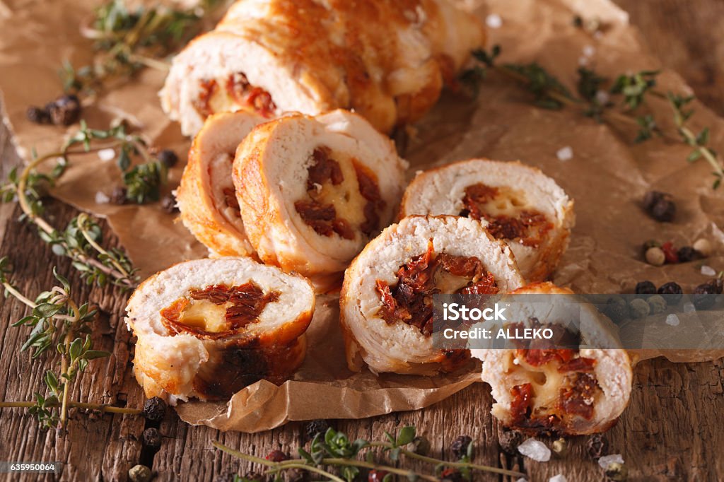 Chicken roll stuffed with cheese and sun-dried tomatoes close-up Chicken roll stuffed with cheese and sun-dried tomatoes close-up on the table. Horizontal Appetizer Stock Photo