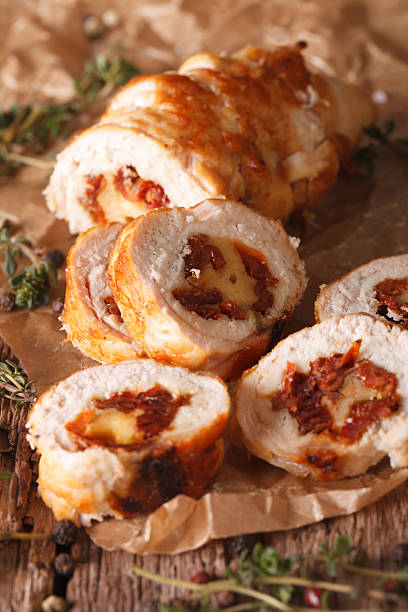 istock Chicken roll with cheese and sundried tomatoes close-up. vertical 635950106