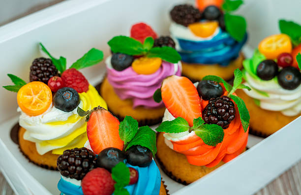 istock Cupcakes with berries in a gift box with a bow. 635953254