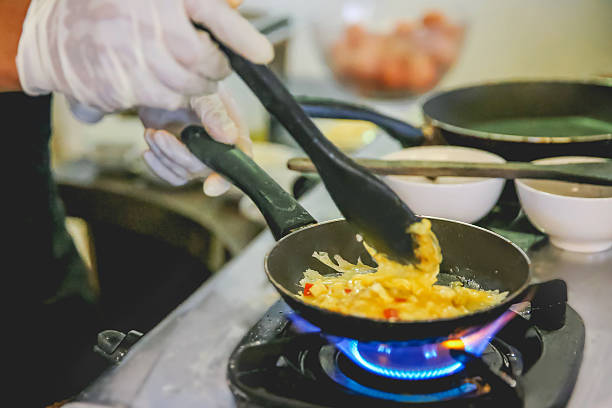 istock Close up adult males cooking scrambled eggs 635953824