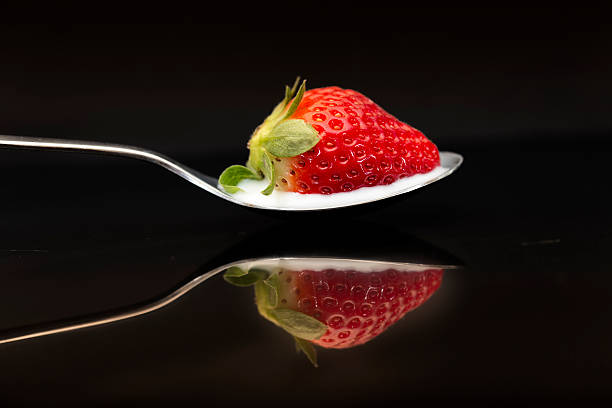 istock Strawberry in spoon on black Bacjground 635956804
