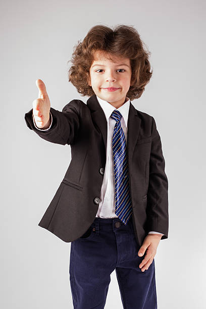 istock Curly happy boy holds out his hand in greeting 635957318