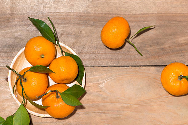 istock Fresh tangerines on wooden background 635957868