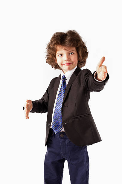 istock Curly boy stands, raised his hands. Gray background. 635958376