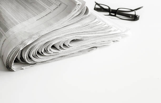 istock Newspapers with eyeglasses on white background 635959920