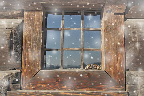 istock old house window in snow. snowflakes falling. wood background, planks. 635960072