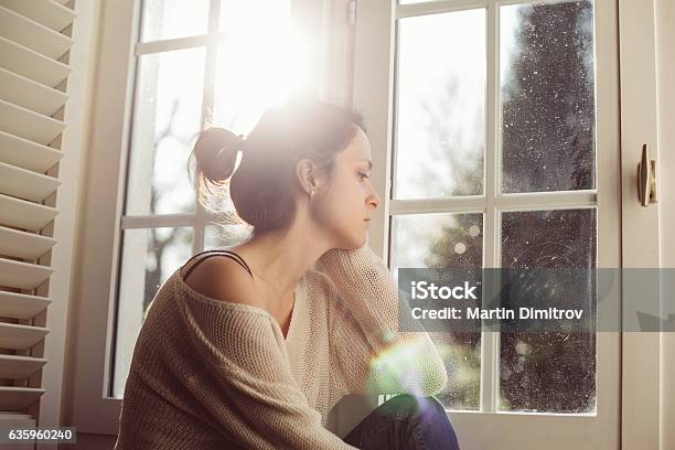 Unhappy Housewife Sitting Near The Window Stock Photo - Download Image Now - Women, Sadness, One Woman Only