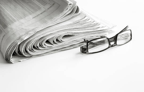 istock Newspapers with eyeglasses on white background 635960252