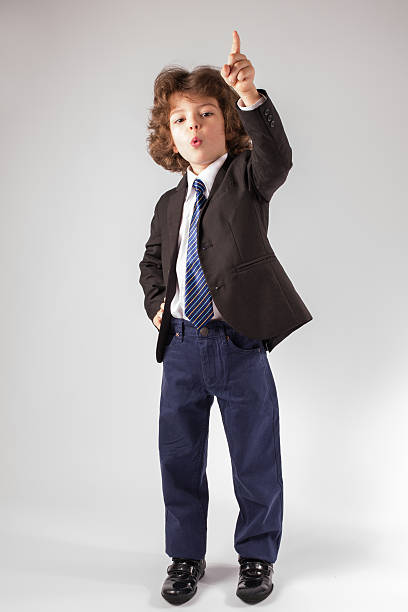 istock Funny curly boy points his index finger upwards. Full length. 635962890