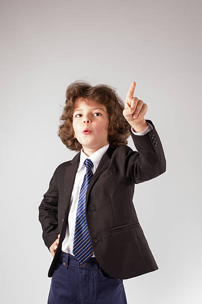 istock Cute boy raised his hand, points his index finger upwards. 635963248