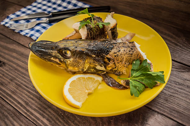 istock Pike baked with vegetables on the table. Wooden rustic background 635966478