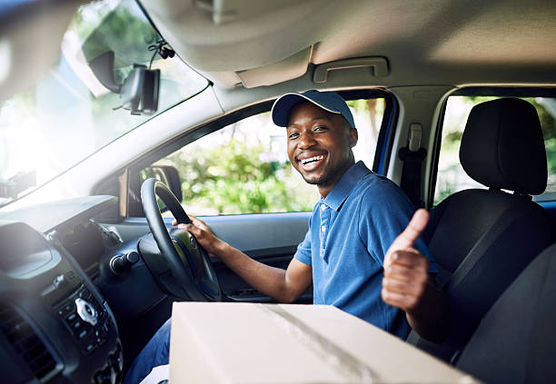 On time, every time Portrait of a young postal working pulling thumbs up while sitting in his car during a delivery car portrait men expertise stock pictures, royalty-free photos & images