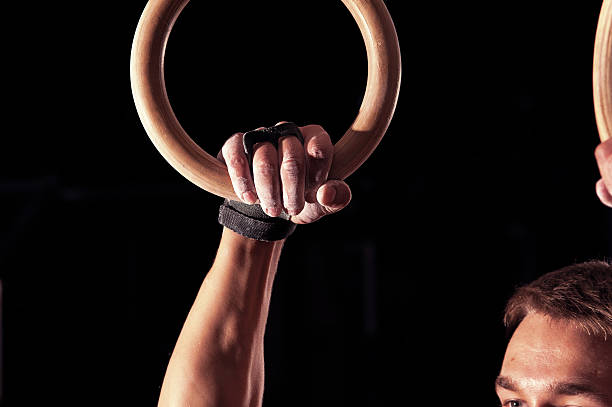 istock Male athlete doing exercises with gymnastics rings 635972344