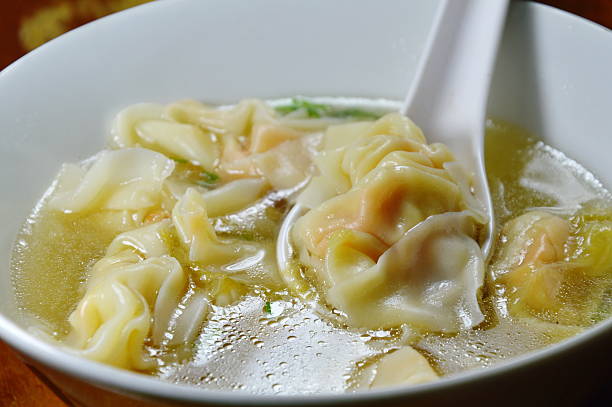 istock Chinese dumpling in clear soup on spoon 635972926