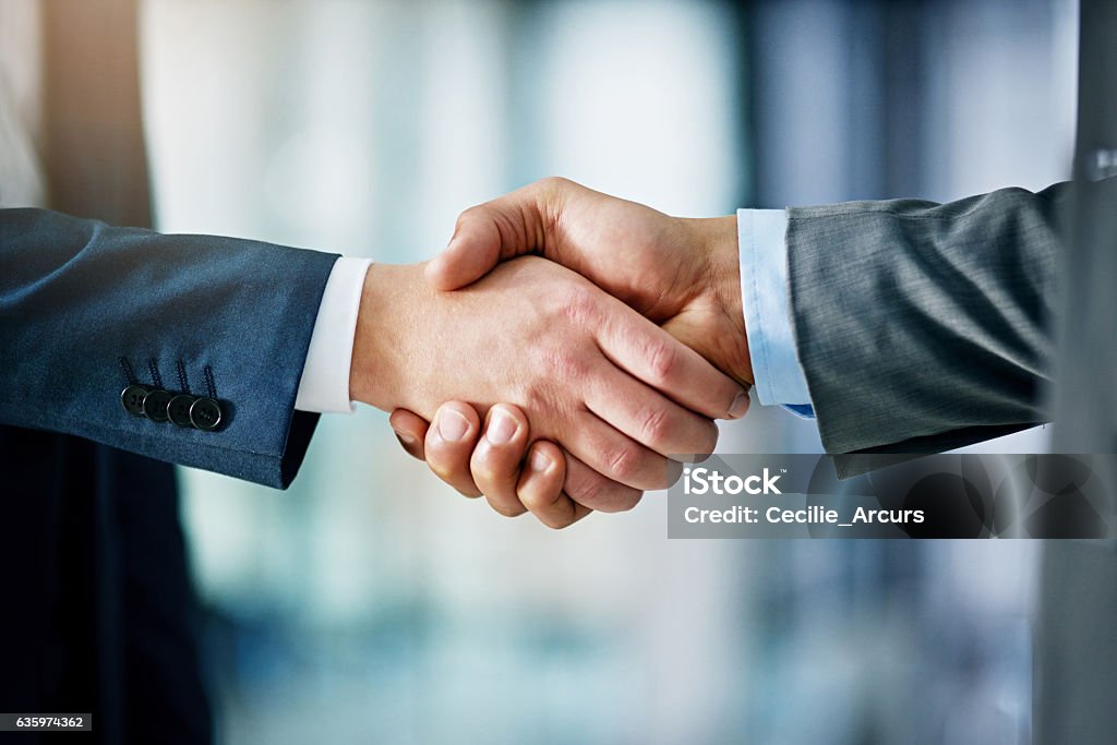 Building a network towards success Closeup shot of two businessmen shaking hands in an office Handshake Stock Photo