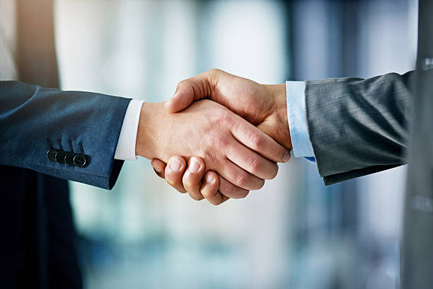 Building a network towards success Closeup shot of two businessmen shaking hands in an office merger stock pictures, royalty-free photos & images