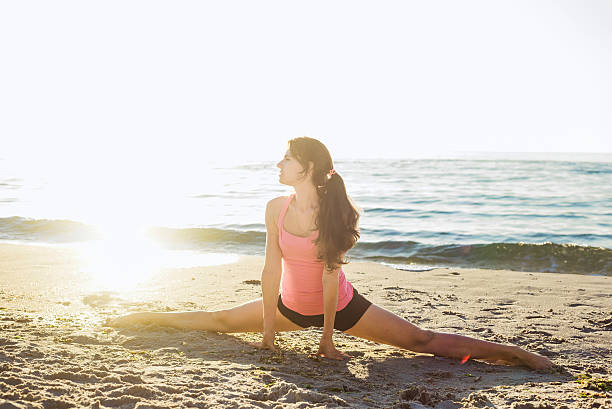 istock young caucasian female doing exercises on the beach 635974370
