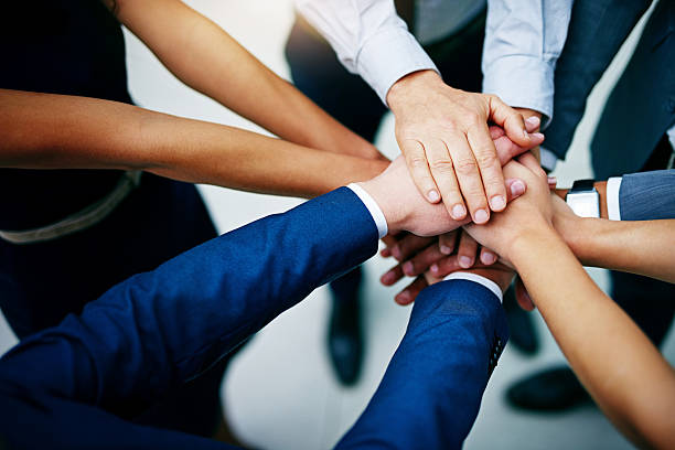 Work together to win together Closeup shot of a group of businesspeople joining their hands together in unity sea of hands stock pictures, royalty-free photos & images