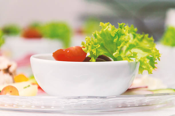 Bowl of fresh vegetable salad on a plate - Stock image