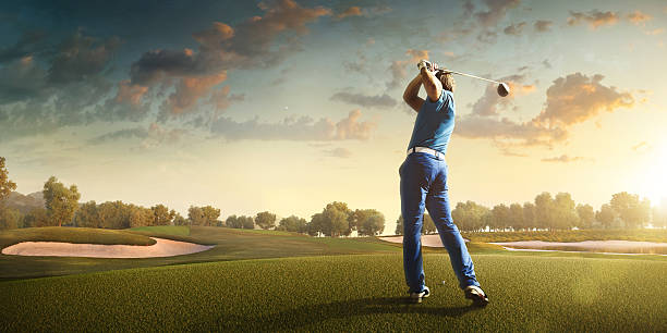 golf: homme jouant au golf dans un terrain de golf - golf golf swing sunset golf course photos et images de collection