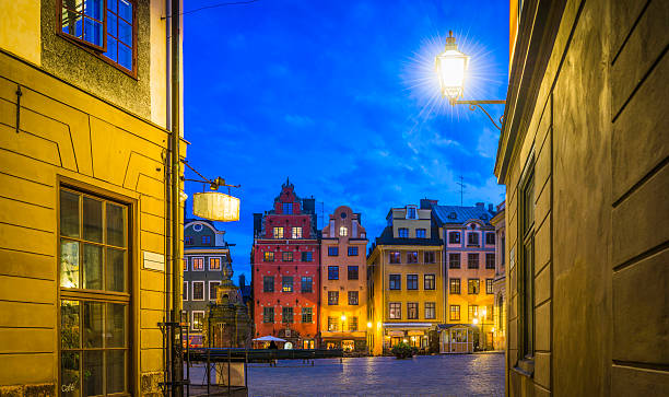 Stockholm Stortorget iconic Gamla Stan square illuminated at night Sweden Warm lamplight illuminating the narrow alleyways leading the colourful townhouses and quaint restaurants of historic Stortorget, Great Square, the iconic landmark plaza on Gamla Stan in the heart of Stockholm, Sweden's vibrant capital city. stortorget stock pictures, royalty-free photos & images