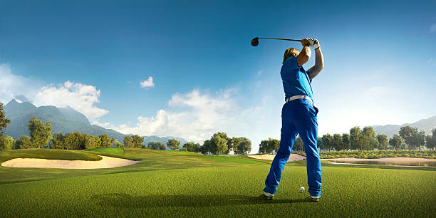 golfe: homem jogando golfe em um campo de golfe - golf golf flag sunset flag - fotografias e filmes do acervo