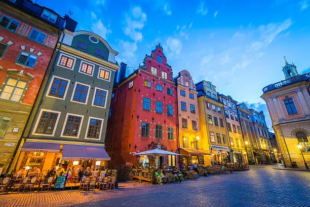 Blue dusk skies above the colourful townhouses and quaint restaurants of historic Stortorget, Great Square, the iconic landmark plaza on Gamla Stan in the heart of Stockholm, Sweden's vibrant capital city.