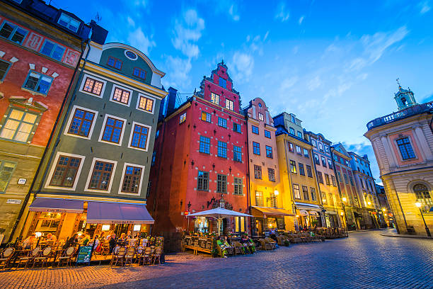 стокгольмские туристы наслаждаются красочными ресторанами stortorget на закате швеции - stockholm стоковые фото и изображения