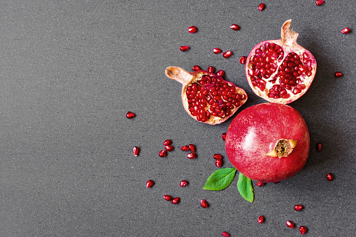 Deliciously Crisp, pomegranate seeds in turquoise bowl & fruits, on wooden background, fresh and juicy.