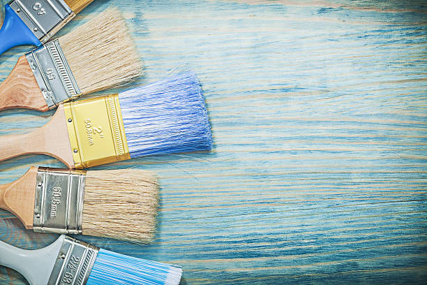 istock Composition of paint brushes on wood board construction concept 635983472
