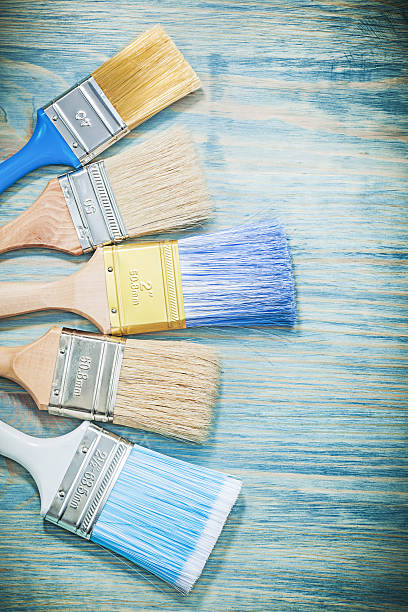 istock Composition of paintbrushes on wooden board construction concept 635983562