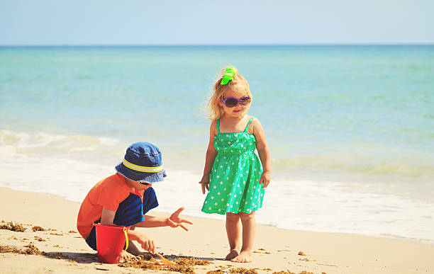 istock kids play with sand on summer beach 635983660