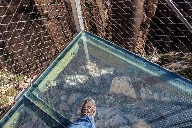 Photo of Trekking shoes over glass footbridge