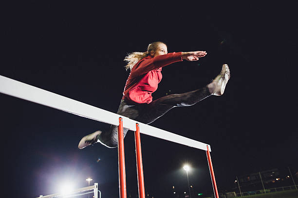 hurdling young athlete - hürdenlauf laufdisziplin stock-fotos und bilder