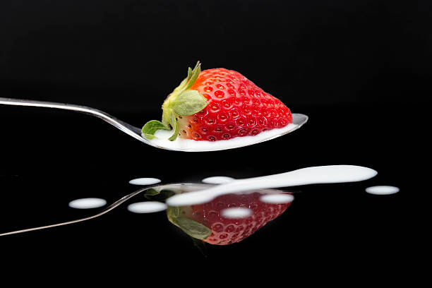 istock Strawberry in spoon on black Bacjground 635991746