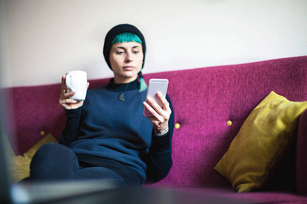 istock Young woman relaxing with smartphone on sofa 635993706