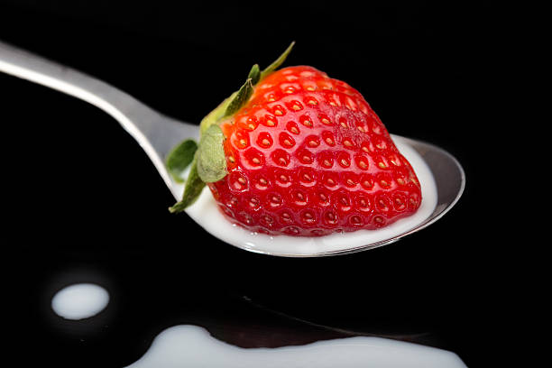 istock Strawberry in spoon on black Bacjground 635994000