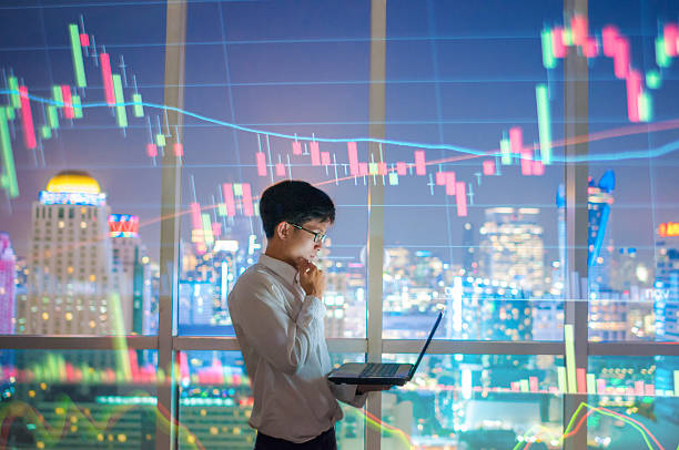 istock Asian Businessman using a laptop and smart phone analysis stock 635997276