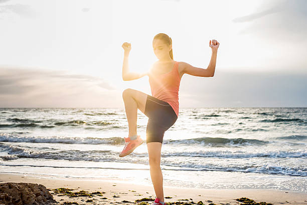istock young caucasian female practicing yoga on beach 635999488
