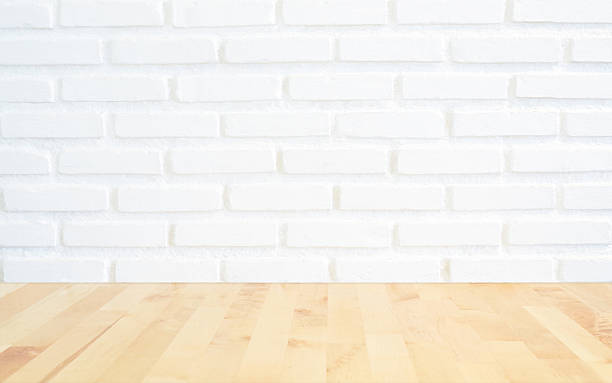 istock White brick wall background with perspective light wood, slightl 636000324