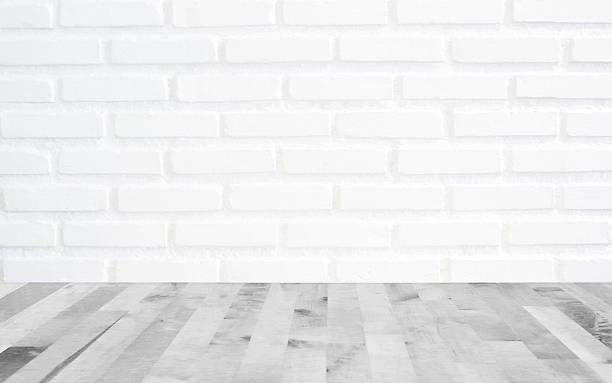 istock White brick wall background with perspective light wood, slightl 636000376