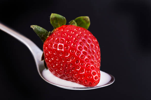 istock Strawberry in spoon on black Bacjground 636001272